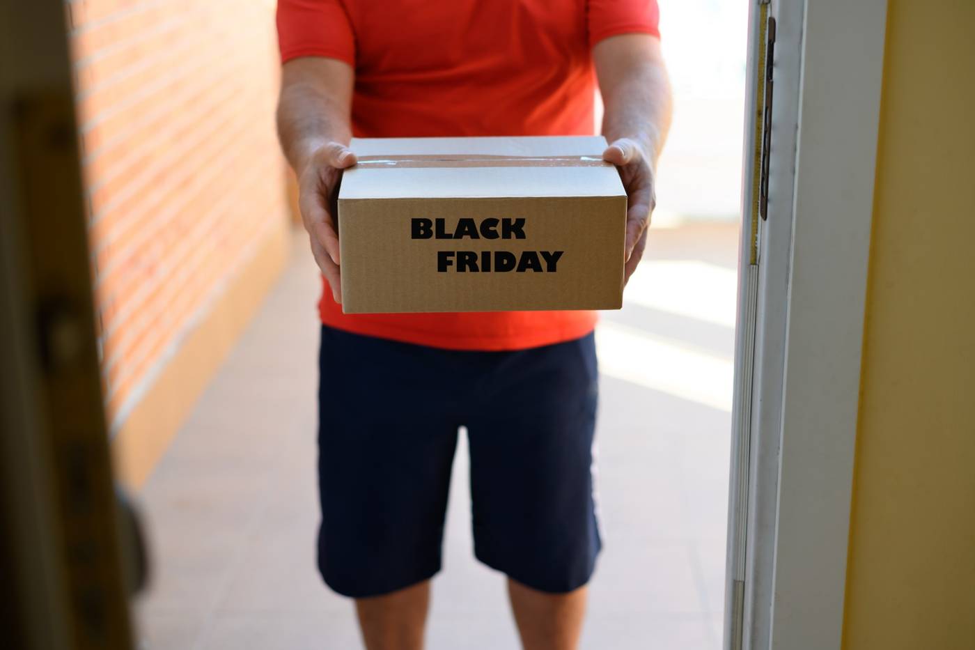Bud lämnar ett paket märkt Black Friday vid ytterdörren